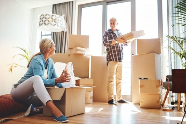 Couple opening their moving house storage packed in boxes